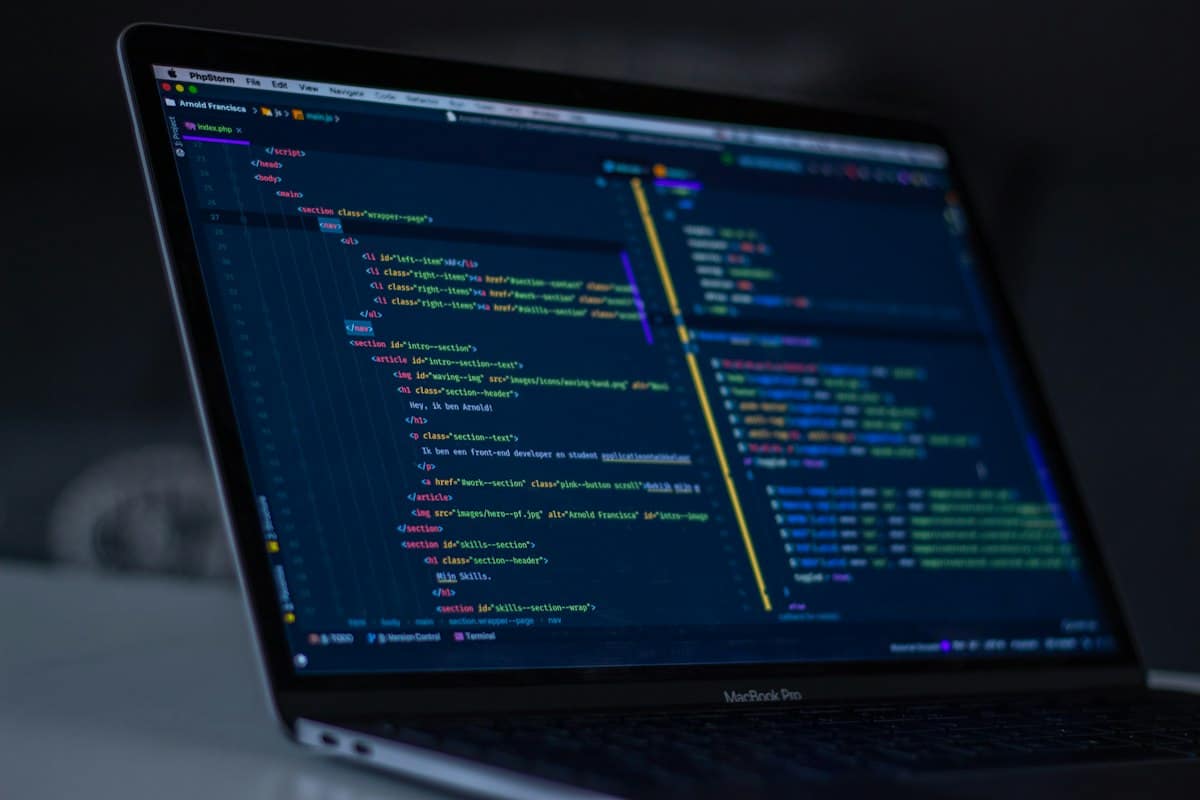 Source code on a laptop screen in a dark room