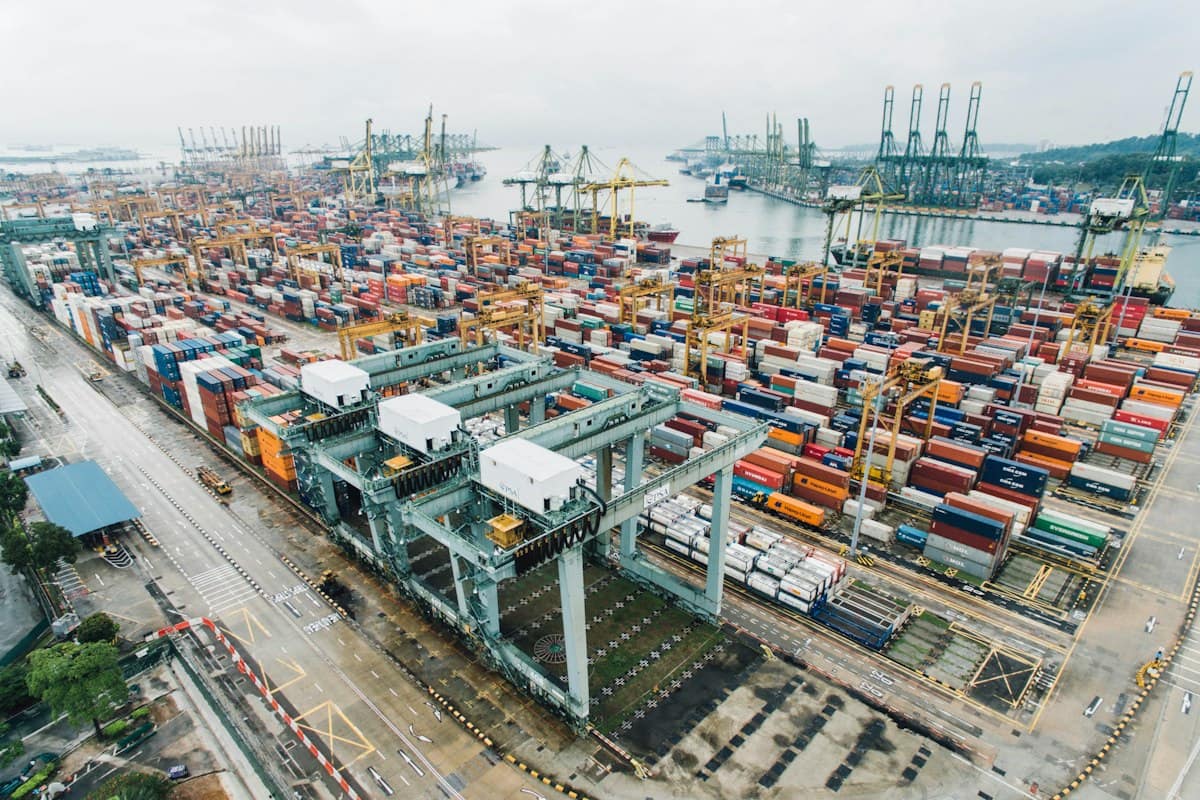 Pemandangan udara pelabuhan peti kemas yang sibuk dengan crane dan tumpukan kontainer