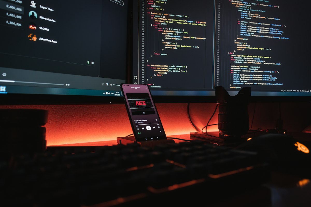Ponsel Android di samping laptop yang menampilkan kode